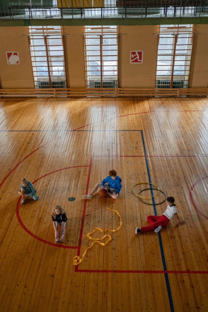 Children Practicing Gymnastic on Wooden Floor